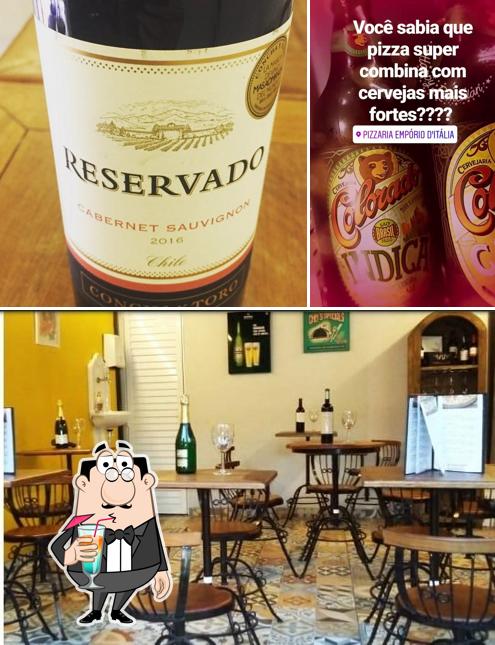 Entre diversos coisas, bebida e mesa de jantar podem ser encontrados no Empório d'Itália Pizzaria - Unidade Catete