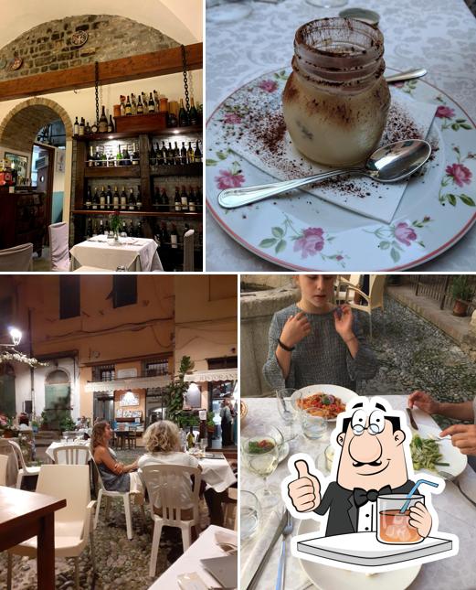 La foto della bevanda e tavolo da pranzo di Urbicia Vivas Ristorante