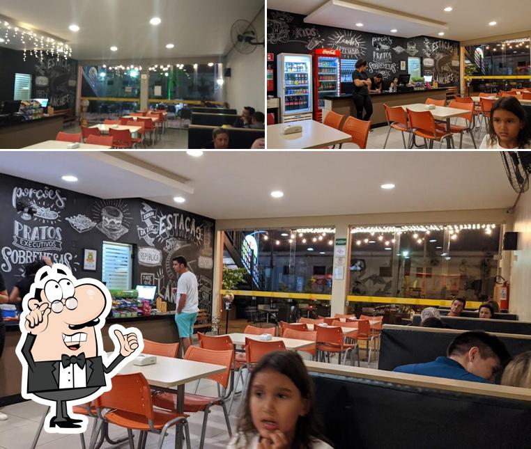 Sente em uma das mesas no Estação Lanches