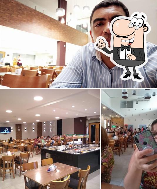 Sente em uma das mesas no Costa Sul Restaurante e Churrascaria