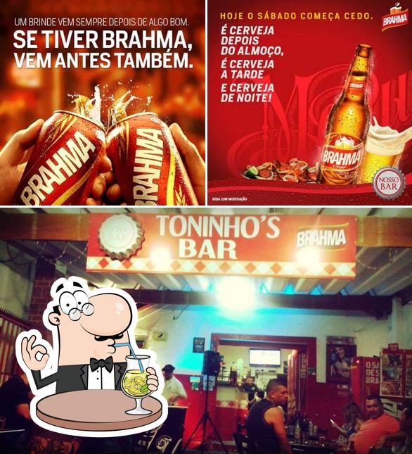 Confira a imagem apresentando bebida e interior no Toninho's Bar