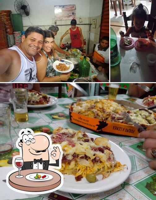 O Pizzaria Do Baixinho se destaca pelo comida e mesa de jantar