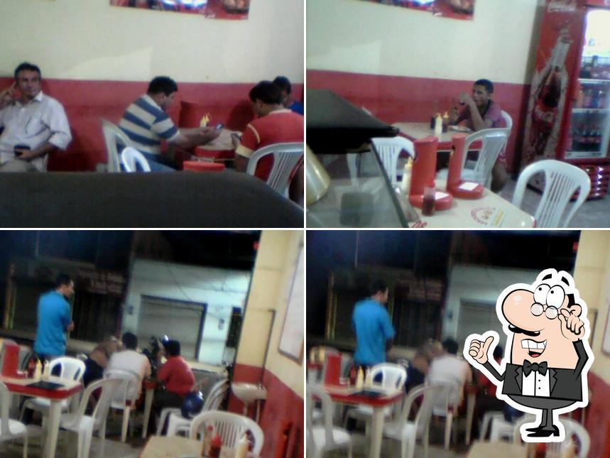 Sente em uma das mesas no Pizzaria & Lanchonete Q'Delicia