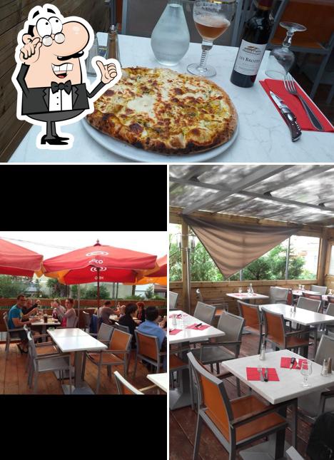 Take a look at the image showing interior and pizza at Le Petit Napoli Villeneuve-Tolosane