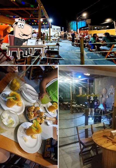 Sente em uma das mesas no Ôxe Bar