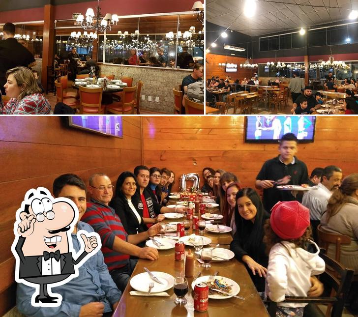 Sente em uma das mesas no Cia do Sabor Pizzaria e Rodízio