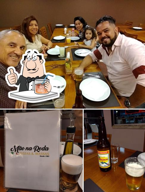 Confira a ilustração ilustrando bebida e mesa de jantar a Mão Na Roda Pizzaria E Chopperia