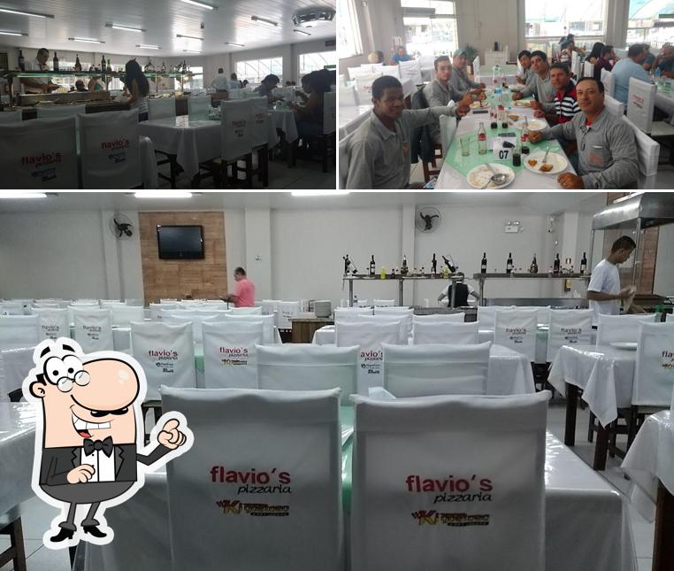 Sente em uma das mesas no Flávios Pizzaria e Restaurante