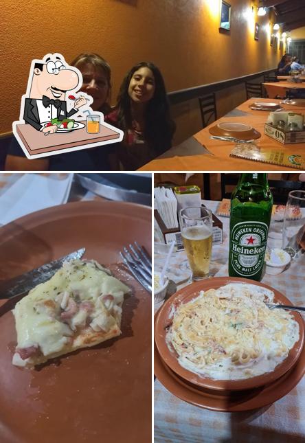 Entre diversos coisas, comida e mesa de jantar podem ser encontrados no Pizzaria do Roberto