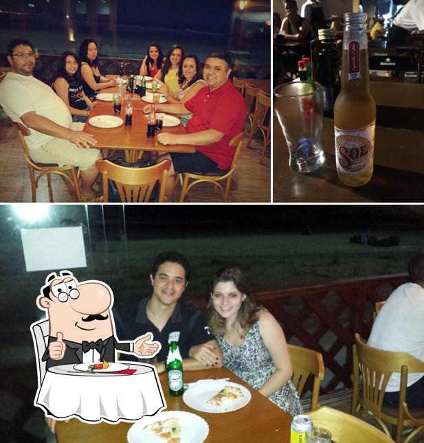 Confira a foto ilustrando mesa de jantar e cerveja no Via Del Mar Pizza Bar