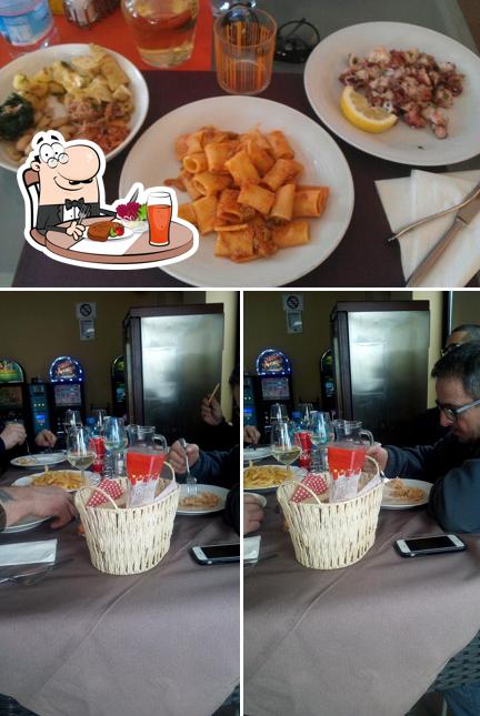 Dai un’occhiata alla foto che mostra la tavolo da pranzo e cibo di Orange Bar