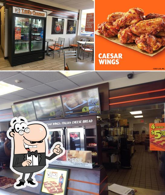 Это снимок, где изображены внутреннее оформление и мясные блюда в Little Caesars Pizza