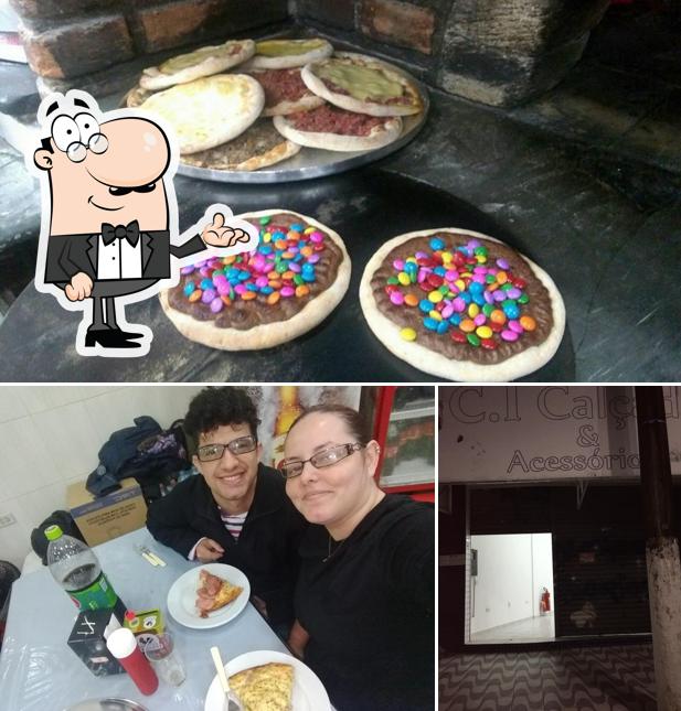 Confira a foto apresentando interior e comida no Pizzaria Família de Praia Grande