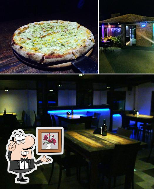 Confira a imagem ilustrando interior e pizza a Pedra Ferro Pizza