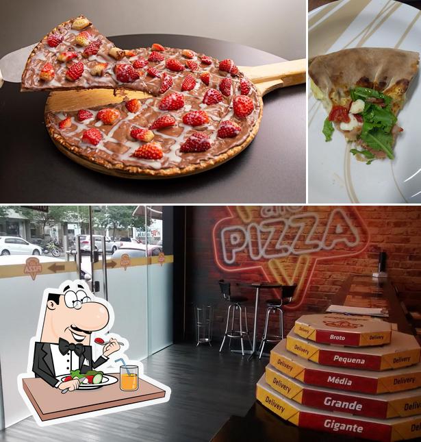 A imagem da comida e interior a Alô Pizza