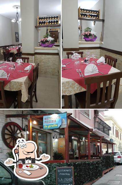 La foto di tavolo da pranzo e esterno da Ristorante Pizzeria La Grotta