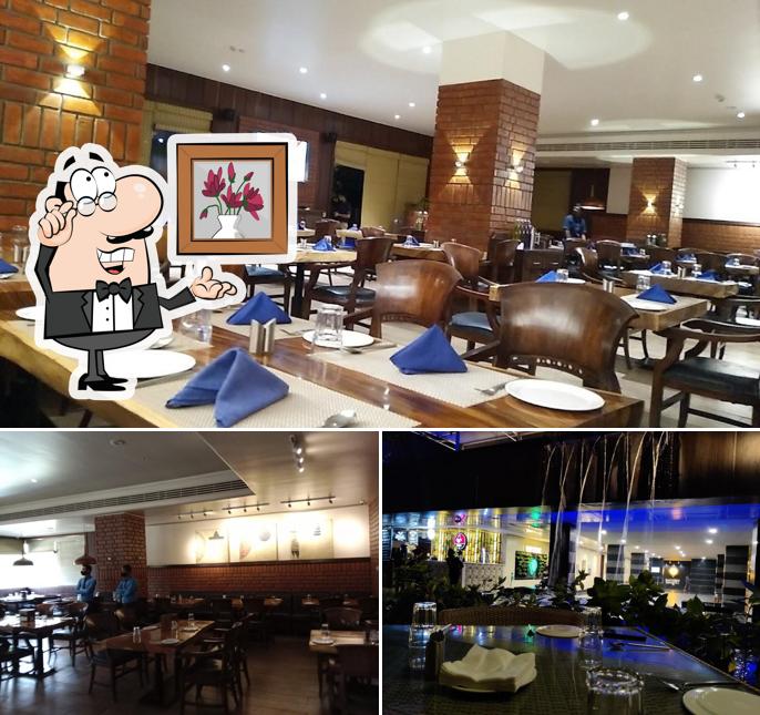 Take a seat at one of the tables at Blue Water Multi Cuisine Restaurant & Banquet
