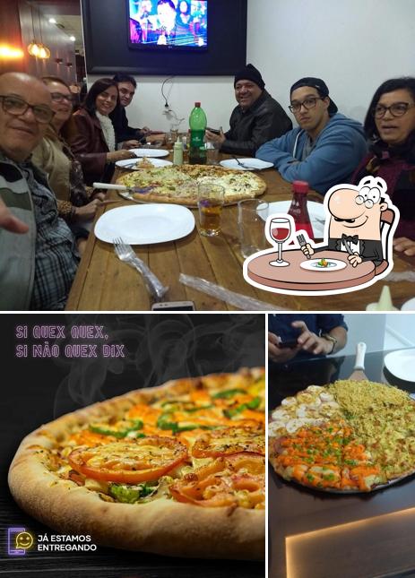 O Pizzaria Dom Camilo - Balneário Camboriú se destaca pelo comida e mesa de jantar