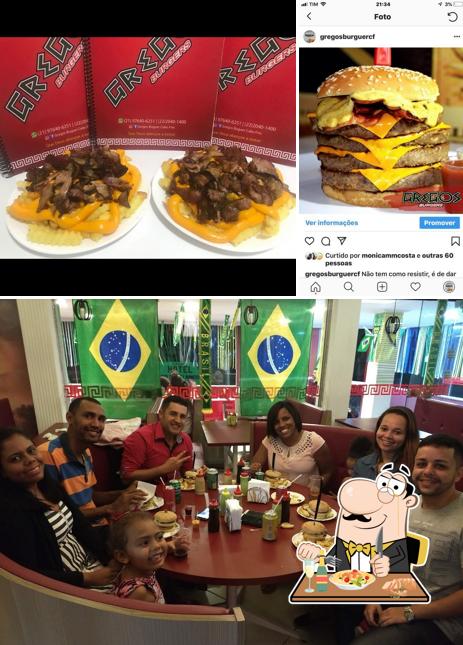 A imagem do Gregos Burgers’s comida e mesa de jantar