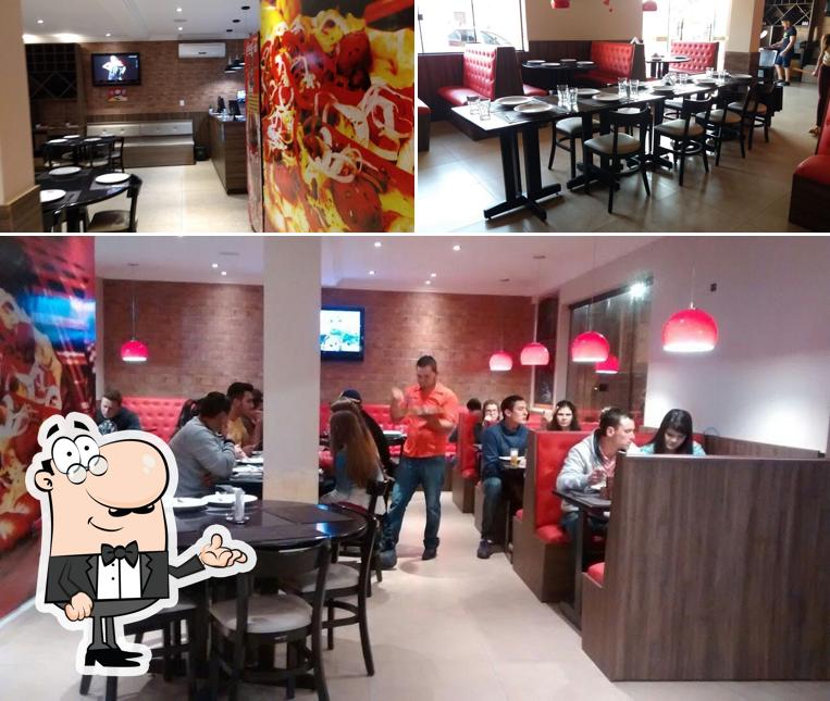 Sente em uma das mesas no Tortelli Pizzarias