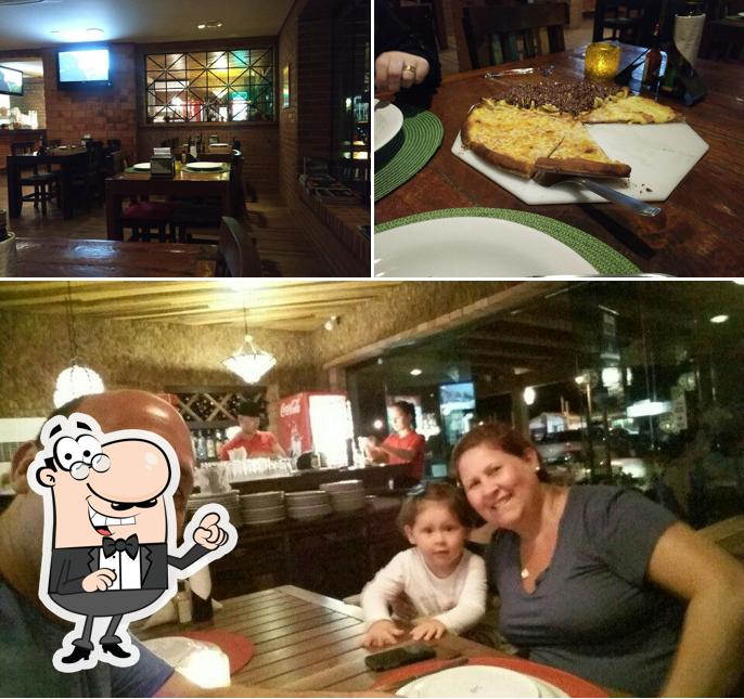 Sente em uma das mesas no GAROPABA PIZZARIA CAESARS A MELHOR PIZZA E FEITA AQUI!