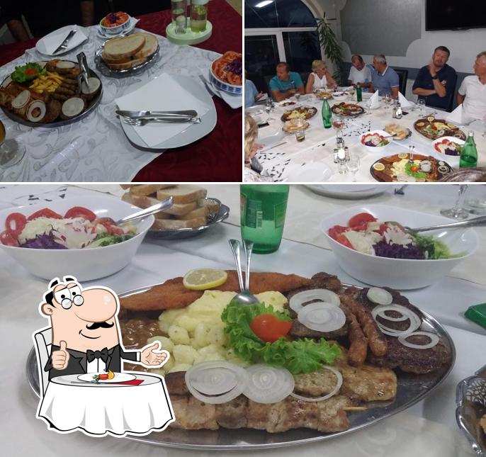 Questa è la foto che presenta la tavolo da pranzo e cibo di Restoran Raj