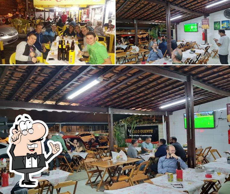 Sente em uma das mesas no Bar e Restaurante Galo Quente