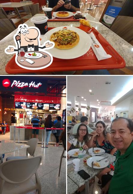 Confira a imagem apresentando mesa de jantar e interior no Pizza Hut