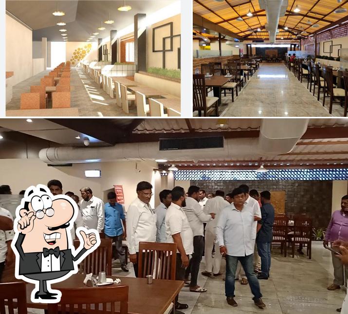 Take a seat at one of the tables at Srigandha Veg & Non Veg Family Restaurant