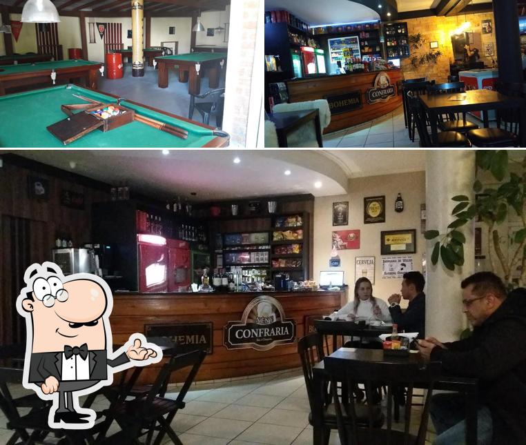 Sente em uma das mesas no Neny Confraria Bar e Choperia