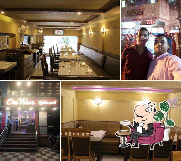 Take a seat at one of the tables at Om Vihar Restaurant