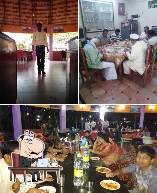 Take a seat at one of the tables at J.K.S North Indian Restaurant Koppal