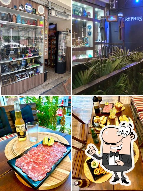 Sente em uma das mesas no Gryphus Tabacaria & Headshop