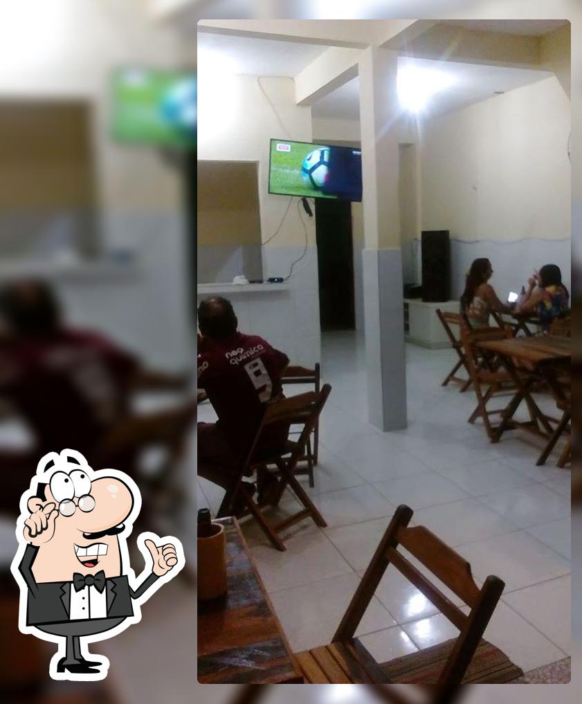 Sente em uma das mesas no Espetinho Do Nenem