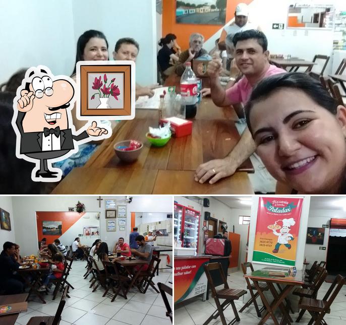 Sente em uma das mesas no Pizzaria Paladar