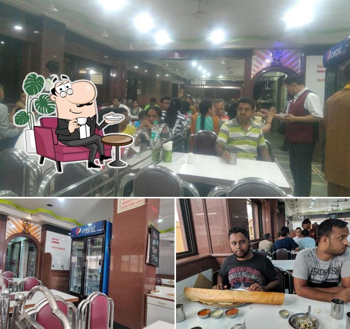 Take a seat at one of the tables at Sarita Vihar Pure Veg Restaurant