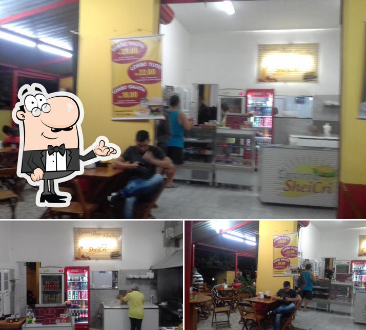 Sente em uma das mesas no Cantinho Sheicri Lanches