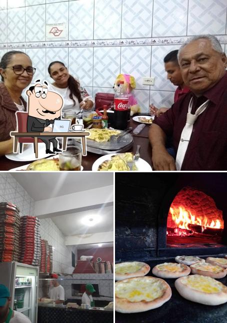 A imagem a Pizzaria Vem Q Boa’s interior e mesa de jantar