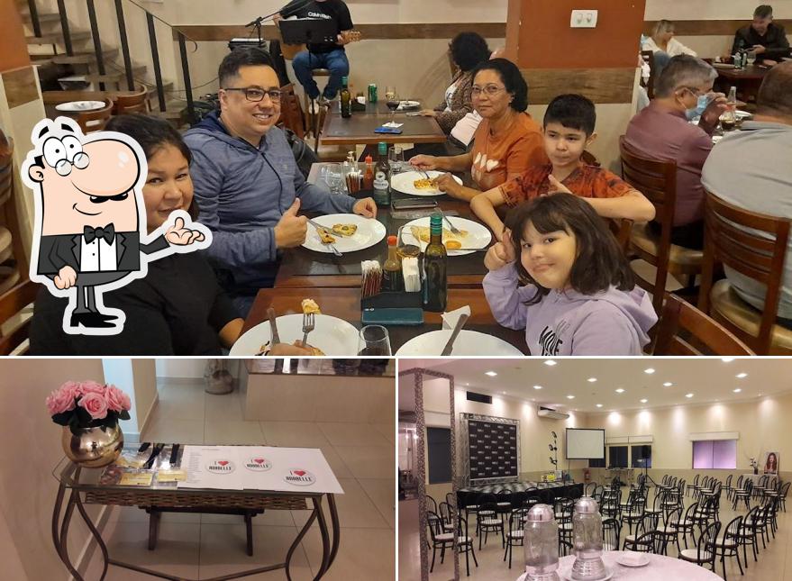 Sente em uma das mesas no Scallet Restaurante e Pizzaria