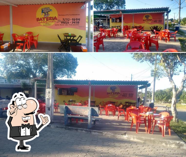 Sente em uma das mesas no Bateria Lanches e Pizzaria