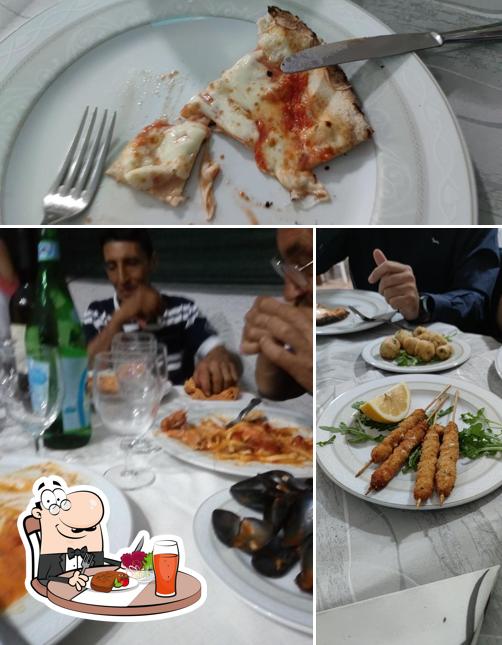 Guarda la immagine che mostra la tavolo da pranzo e cibo di La Perla Dei Sapori