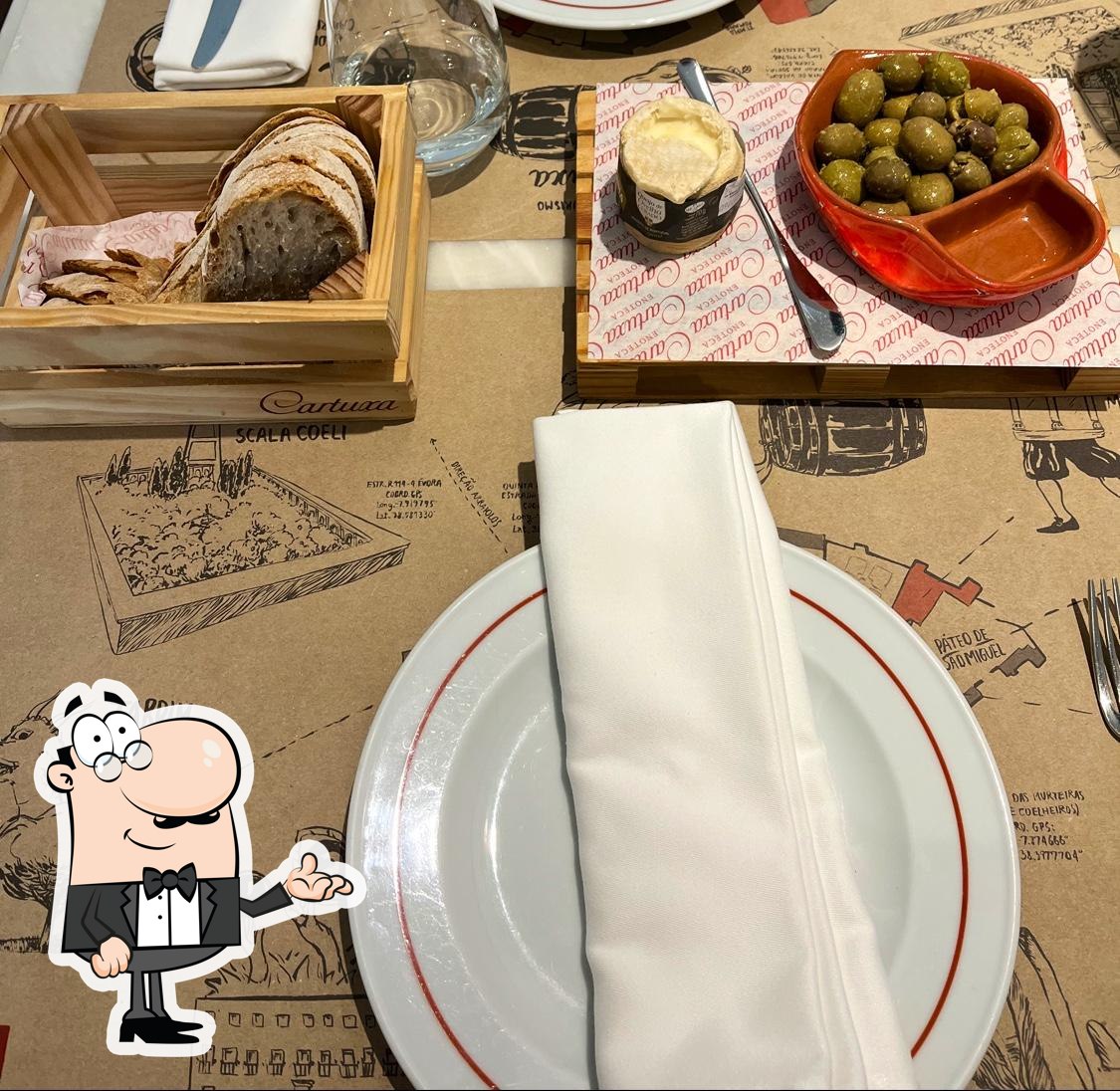 Sente em uma das mesas no Enoteca Cartuxa.