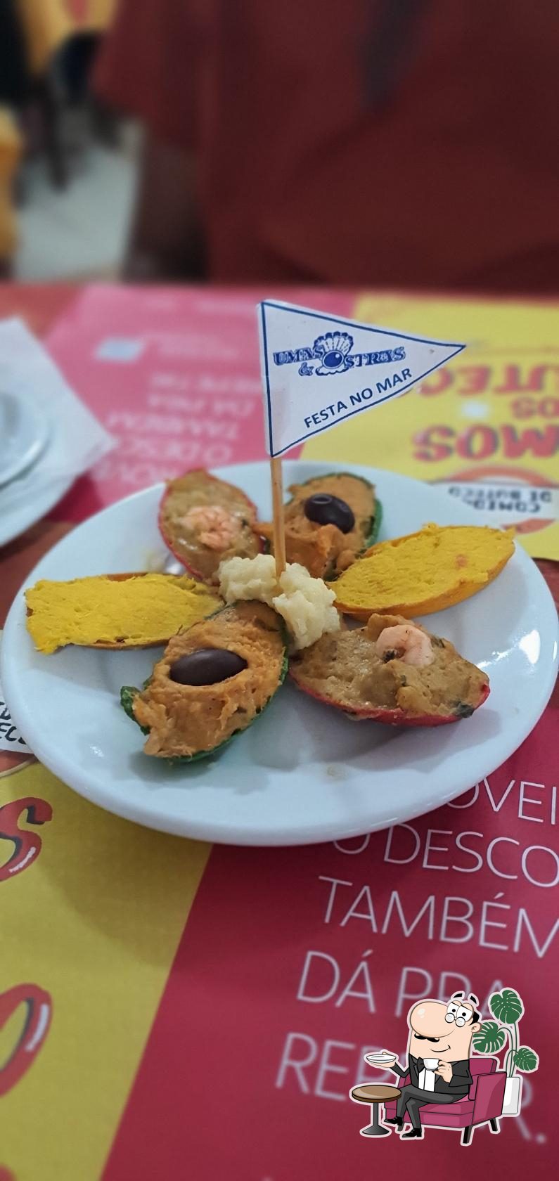 Sente em uma das mesas no Restaurante Umas & Ostras.