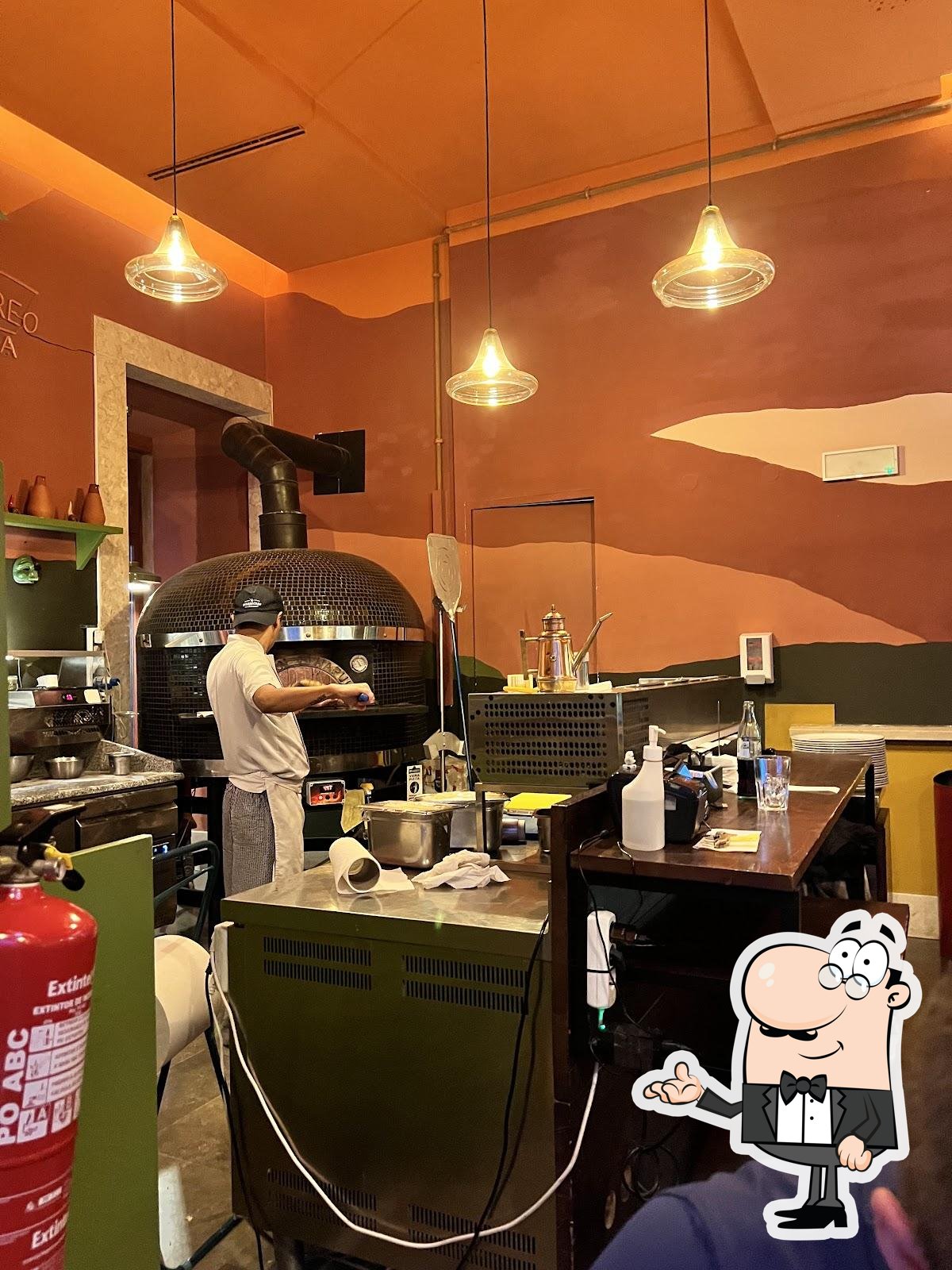 Sente em uma das mesas no M’arrecreo Pizzeria.