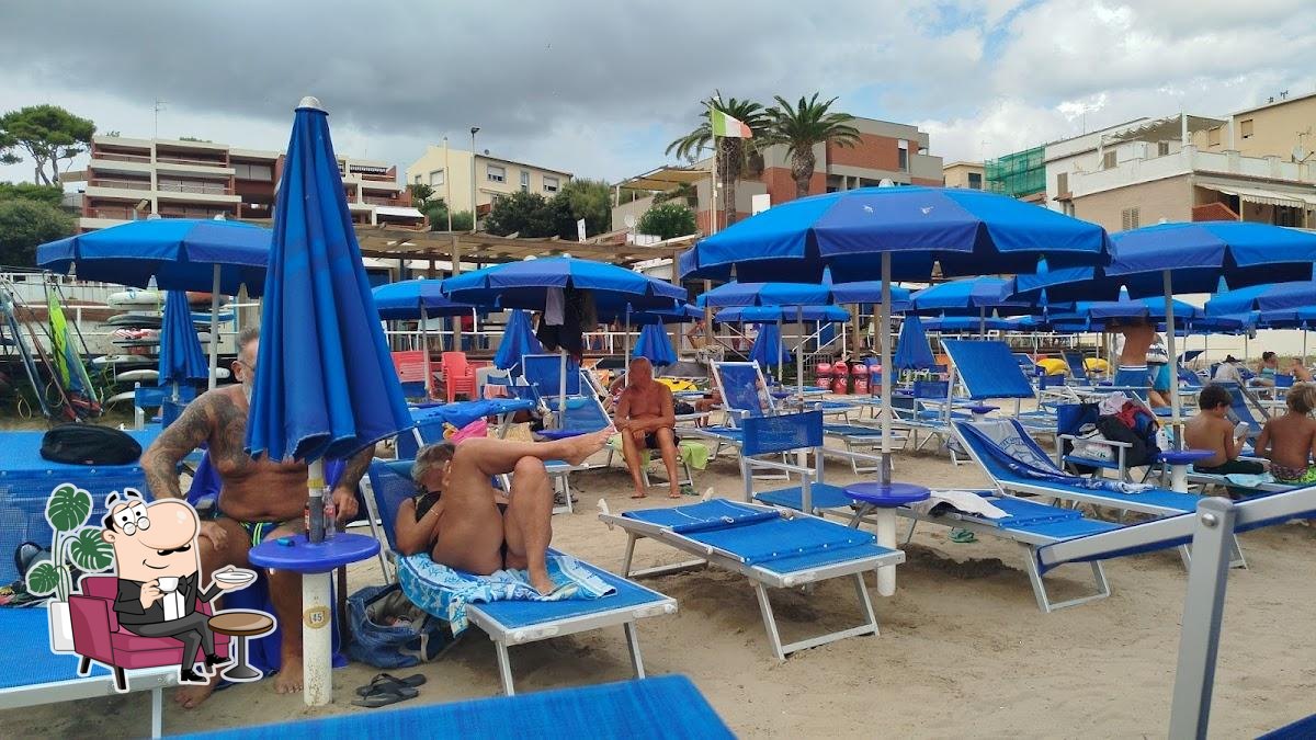 Siediti a un tavolo di Al Solito Posto Beach.