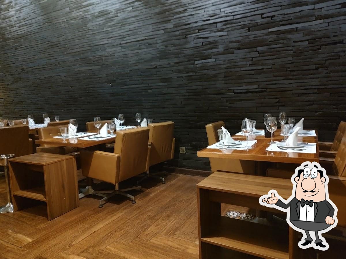 Sente em uma das mesas no Restaurante d'Oliva.