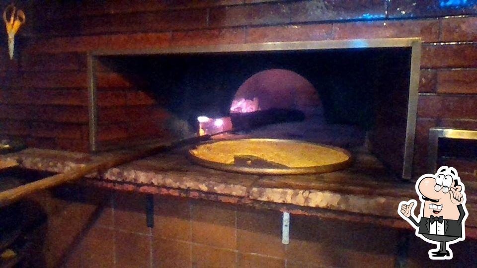 Siediti a un tavolo di Pizzeria Bar Roma.