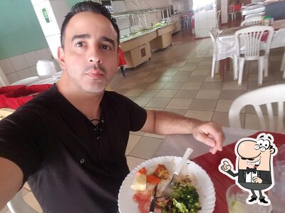Sente em uma das mesas no Restaurante e Pizzaria Ximenes