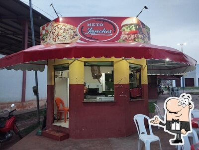Sente em uma das mesas no Neto Lanches