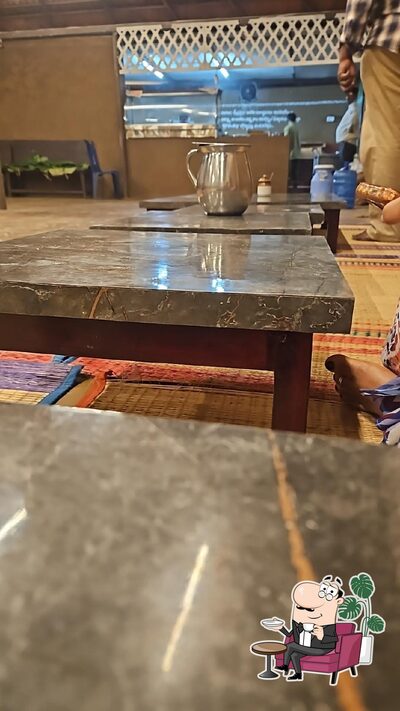 Take a seat at one of the tables at "శ్రీ గోవిందుని గో సేవ అనేది ఒక సాంప్రదాయ భోజనశాల" (Sri Govinduni Go Seva is a traditional restaurant )
